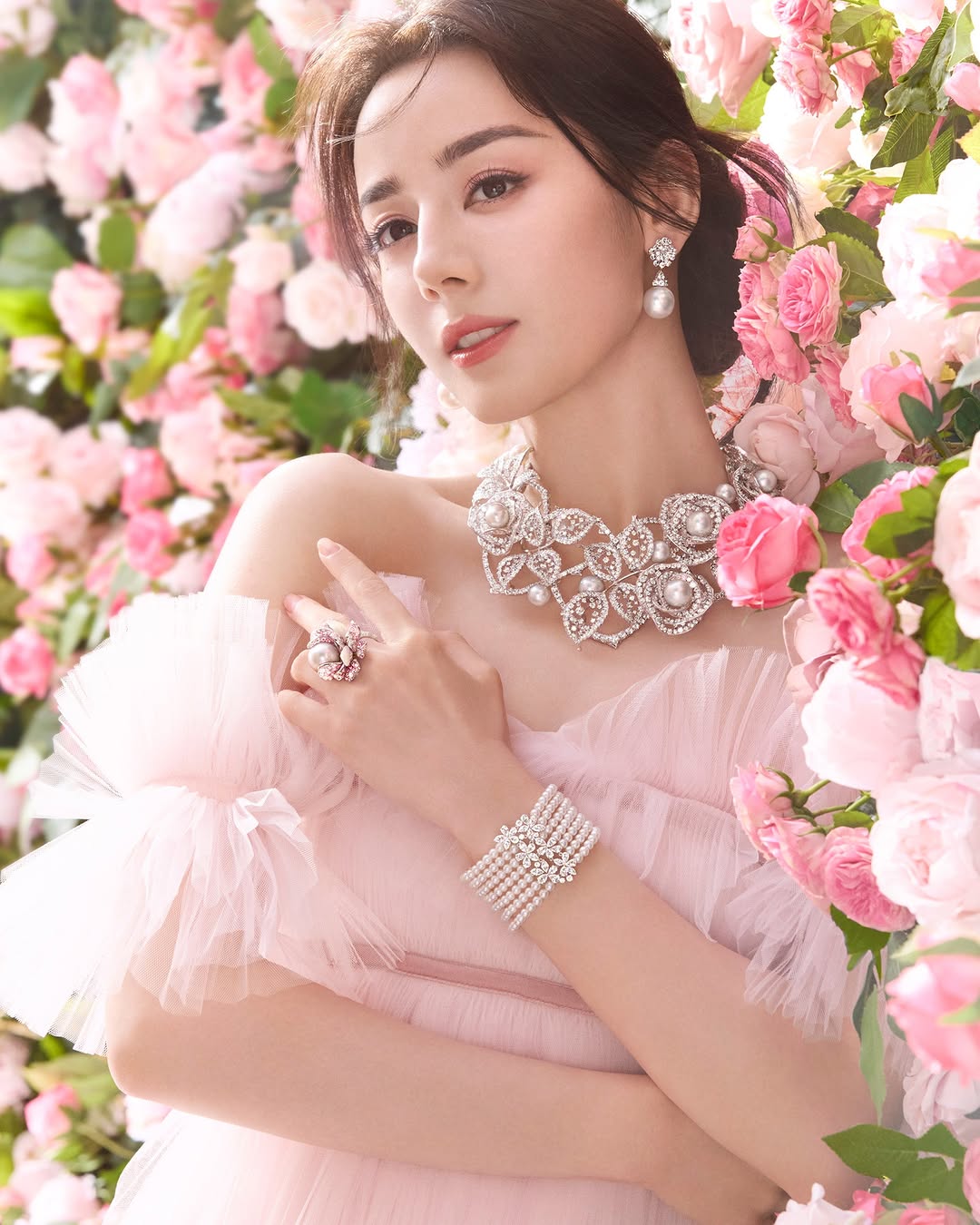 Woman wearing Mikimoto pearls and jewelry with a floral background